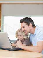 Father and son using laptop together