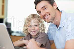 Smiling father and son with notebook