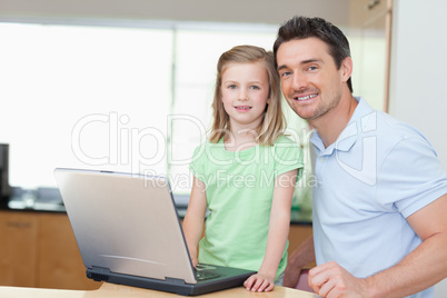 Father and daughter using laptop