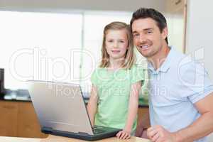 Father and daughter using laptop