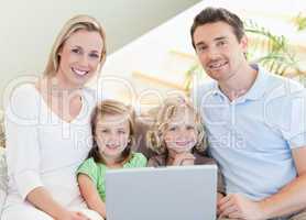 Family with laptop on the sofa