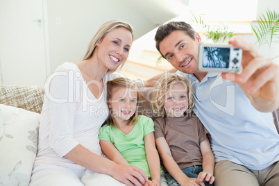 Father taking family picture on sofa