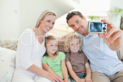 Father taking family picture on couch