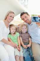 Man taking family picture on sofa