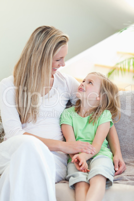 Mother and daughter sitting on couch