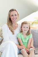 Mother and daughter sitting on sofa together