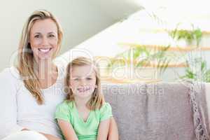 Mother and daughter sitting on couch together