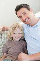 Father and son sitting on sofa