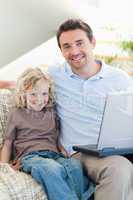 Father and son on sofa with laptop
