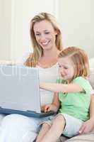 Mother and daughter with laptop on couch