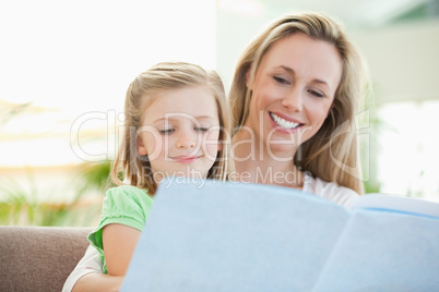 Mother and daughter reading a magazine on the couch
