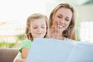 Mother and daughter reading a magazine on the couch