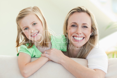 Smiling mother and daughter on the sofa