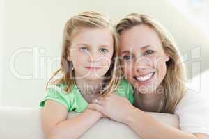 Smiling mother and daughter on the couch