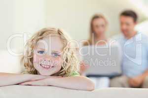 Smiling boy with parents in the background