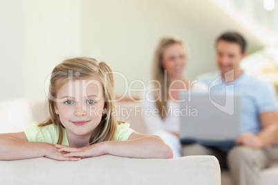 Smiling girl with parents behind her