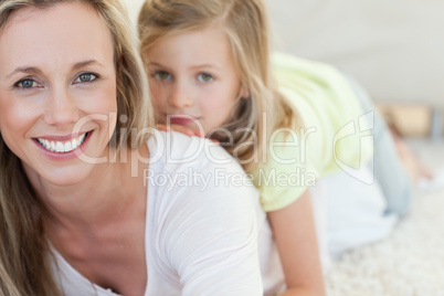 Mother and daughter lying on carpet