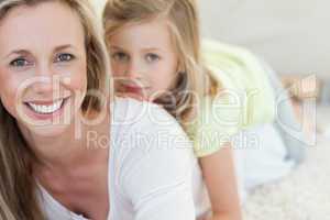 Mother and daughter lying on carpet