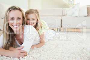 Mother and daughter lying on the floor