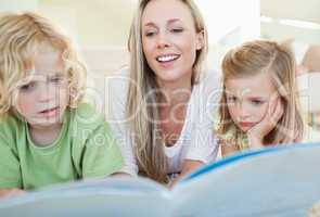 Mother reading magazine with her children