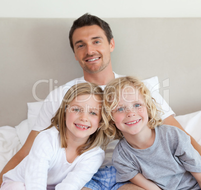 Father sitting on bed with his children