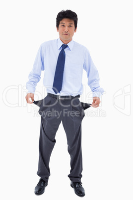 Portrait of a businessman showing his empty pockets