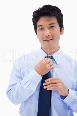 Portrait of a smiling businessman fixing his tie