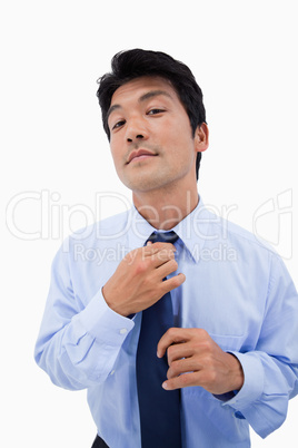 Portrait of a relaxed businessman fixing his tie