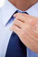 Close up of a businessman fixing his tie