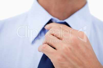 Close up of a hand fixing a tie