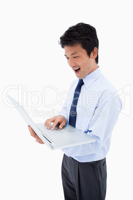 Portrait of a surprised businessman using a laptop