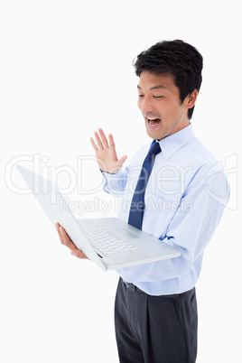 Portrait of a businessman waving at a notebook