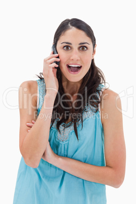 Portrait of an amazed woman making a phone call