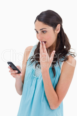 Portrait of a surprised woman reading a text message