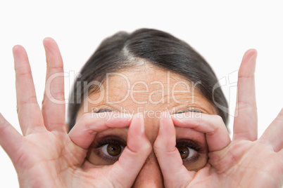 Close up of a woman with her fingers around her eyes