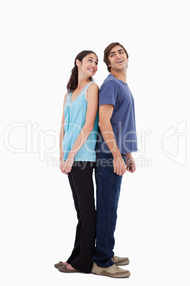 Portrait of a smiling couple standing back to back