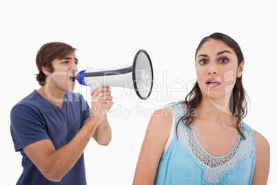 Man yelling at her girlfriend through a megaphone