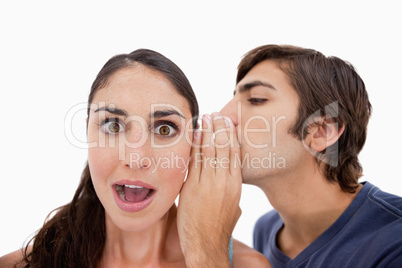 Man whispering something shocking to his fiance