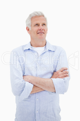 Portrait of a mature man with the arms crossed looking up