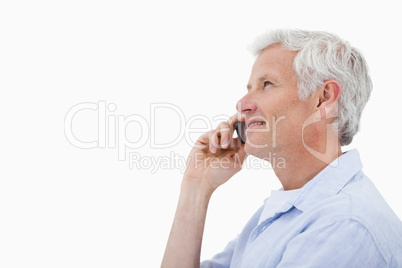 Side view of a smiling mature man making a phone call