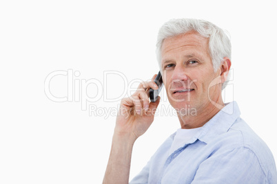 Side view of a man making a phone call while looking at the came