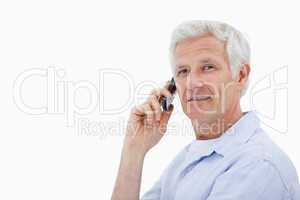 Side view of a man making a phone call while looking at the came