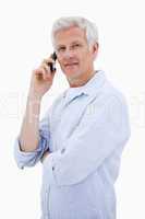 Portrait of a mature man making a phone call while looking at th