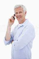 Portrait of a happy man making a phone call while looking at the