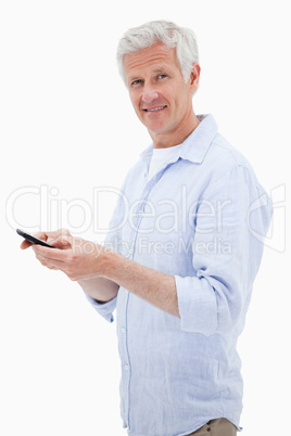 Portrait of a man using his mobile phone while looking at the ca