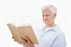Happy mature man reading a book
