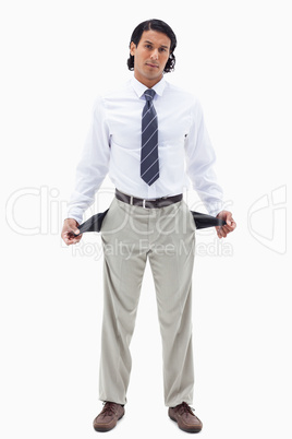 Portrait of a broke businessman showing his empty pockets