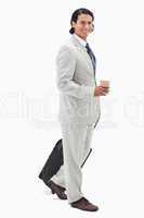 Side view of businessman with coffee and wheely bag