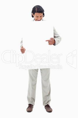 Businessman looking and pointing at blank sign in his hands