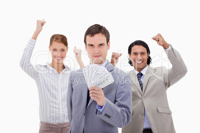 Businessman with cheering colleagues and money